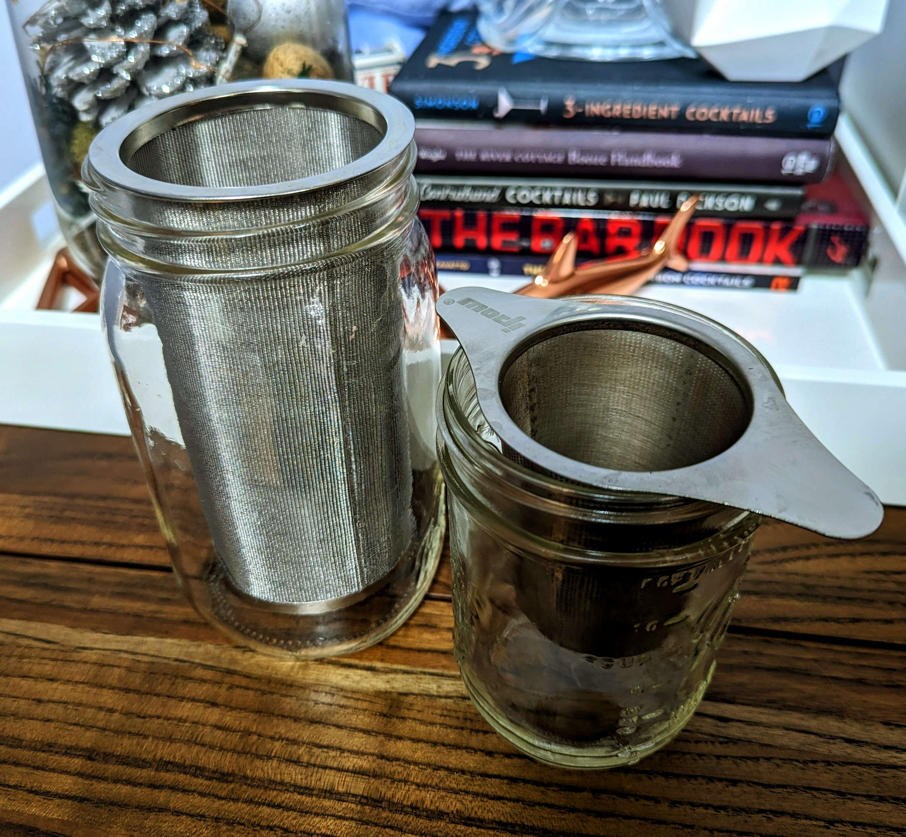 Two mason jars with metal tea-infusers inside.